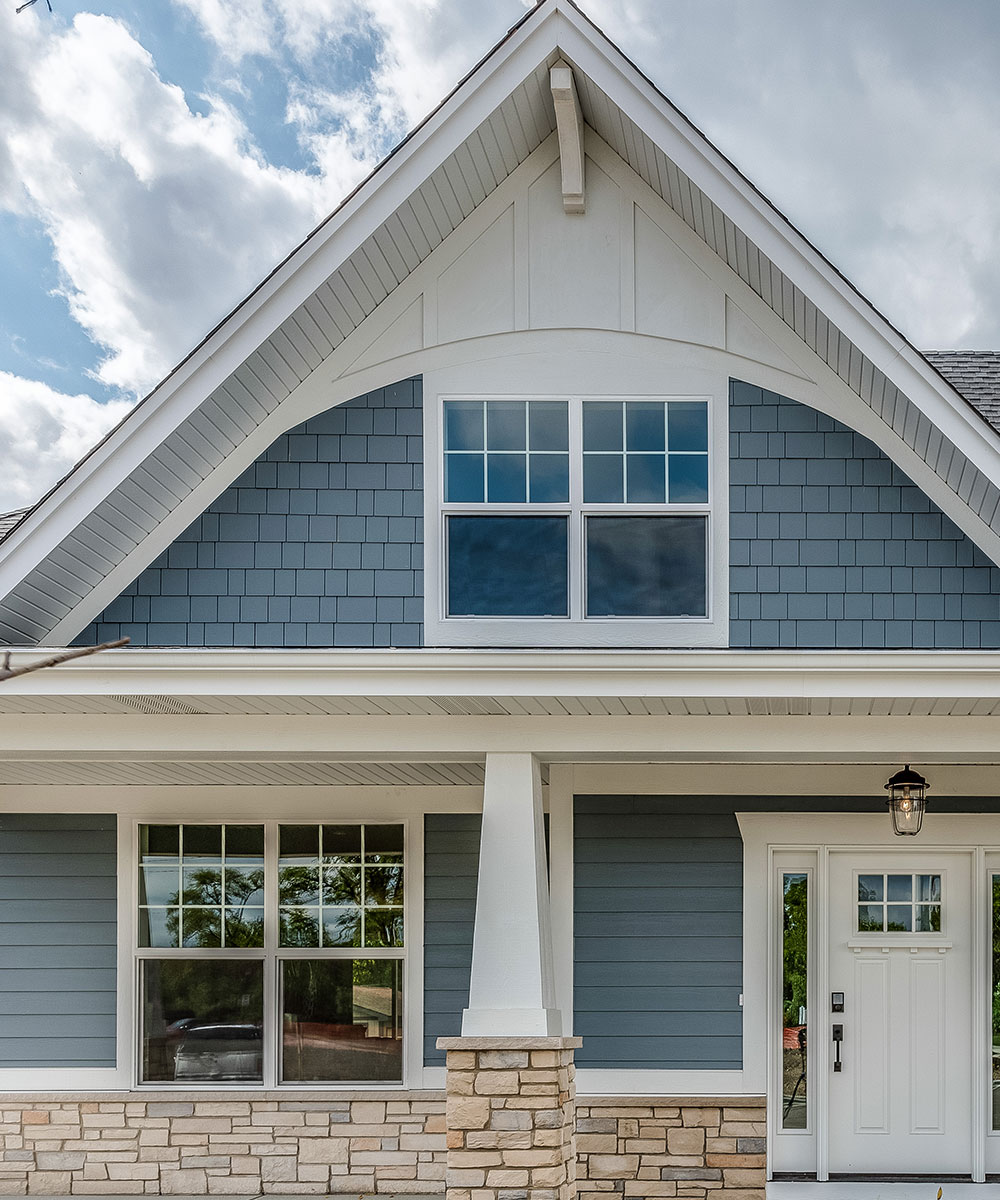 Contractor installing vinyl clapboard siding on a residential home in Springfield, MO, emphasizing precise and professional installation.