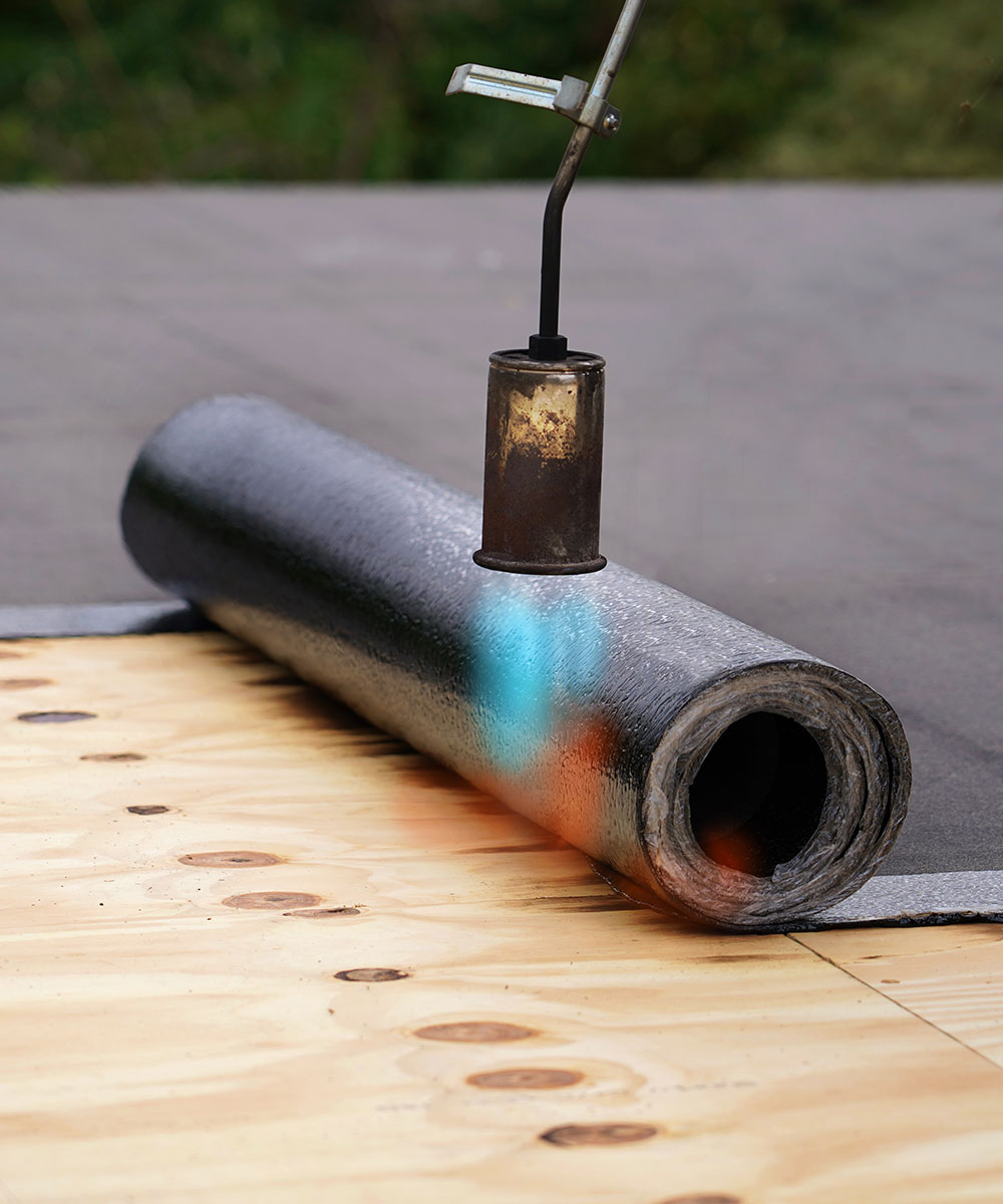 Technician installing TPO roofing materials on a flat roof in Springfield, MO, emphasizing Roof For Less's high-quality flat roof replacement services.