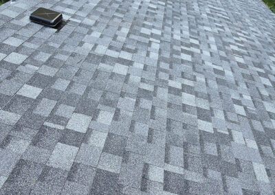 Gray asphalt shingle roofing with ventilation installed on a residential home.