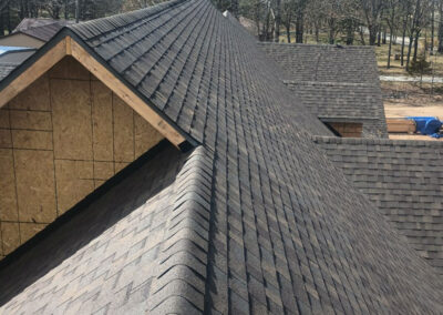 Long view of a roof ridge with neatly installed asphalt shingles on a residential property