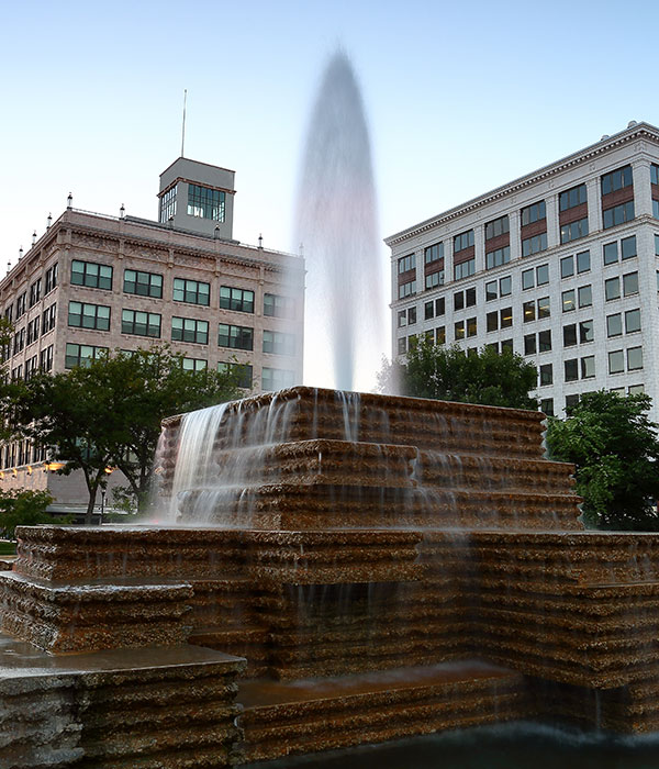 Fountain at Park Central Square in downtown Springfield, MO, surrounded by historic buildings, symbolizing Roof For Less's local service areas.